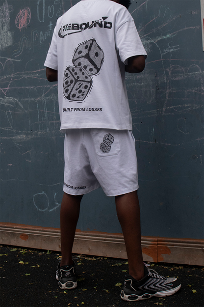 Rebound streetwear model in clean white tee standing confidently in front of blue urban wall